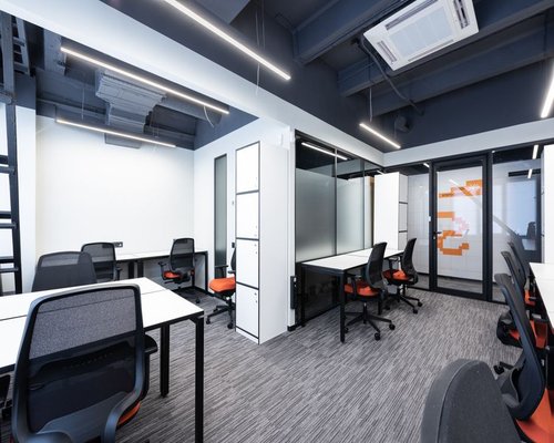 Modern shared office interior in Chile with ergonomic chairs and overhead ambient lighting